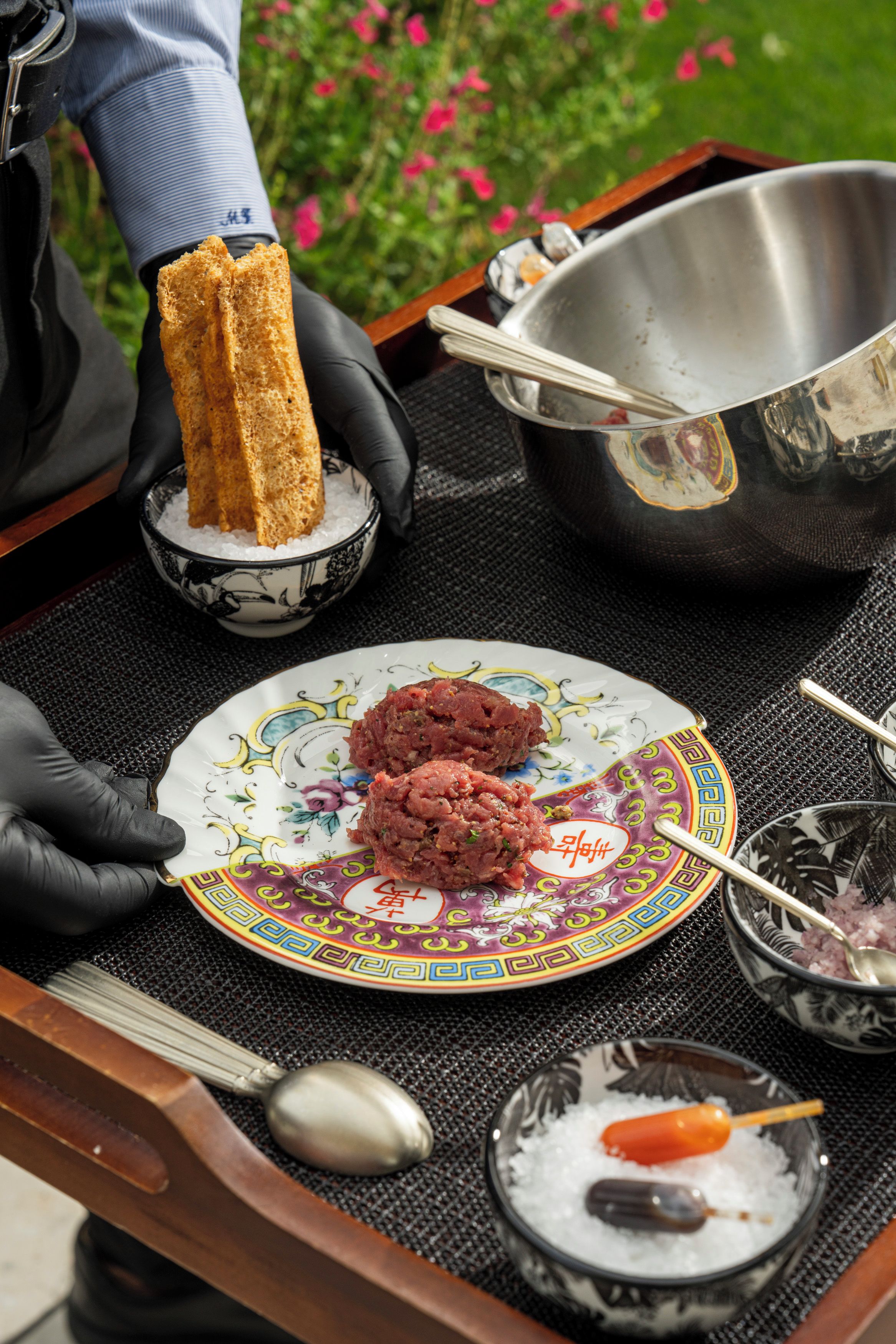 A tray with a plate of food, a bowl of ice, and a spoon.