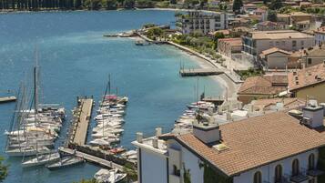 Un hotel sulla costa con piscina, porto turistico e vista sulle colline.