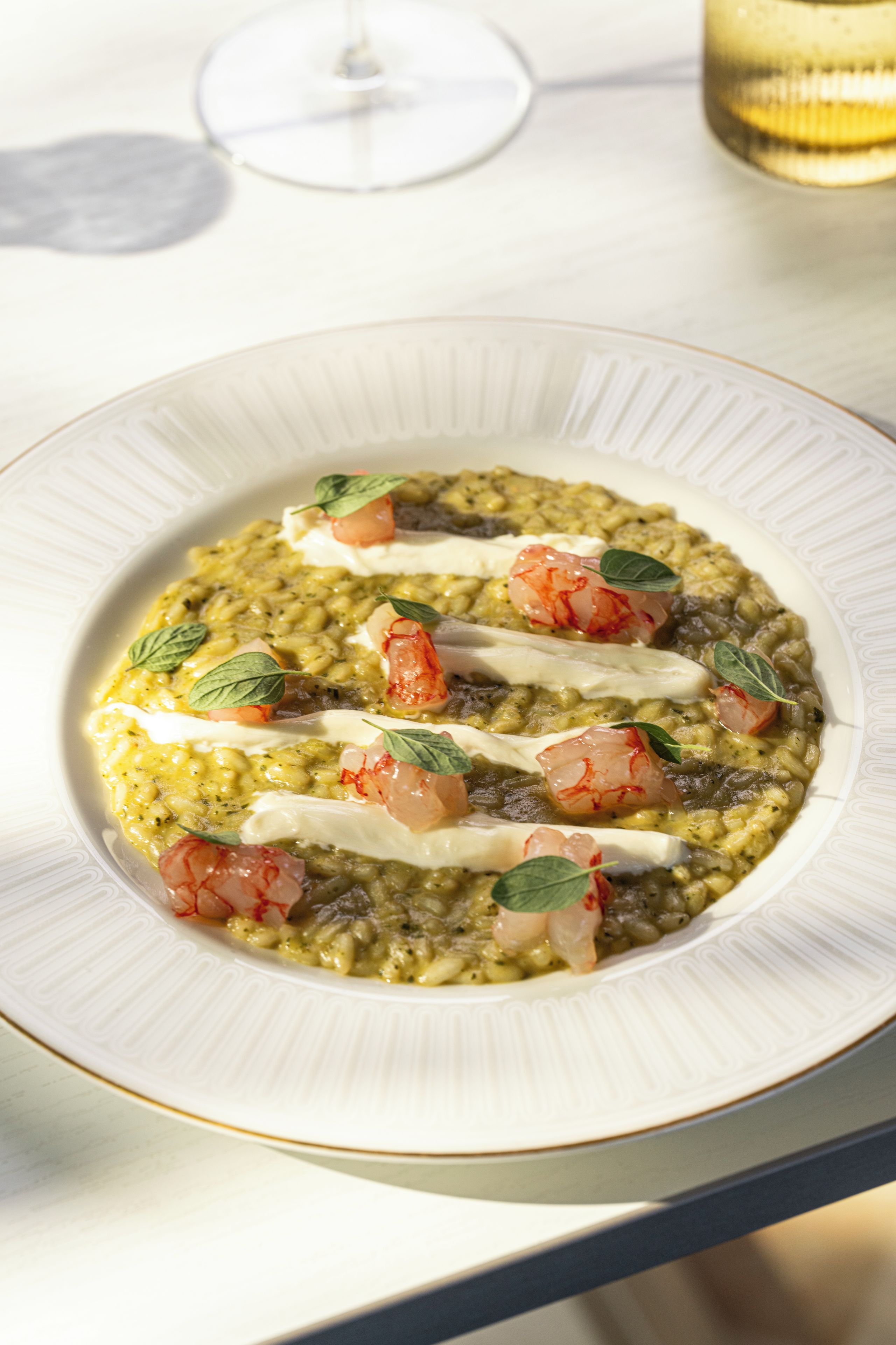 Un plato de comida con salsa cremosa, adornado con hierbas y tomates.