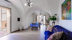 Un intérieur comprenant un coin repas, un canapé et un tableau.