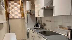 Eine moderne Küche mit weißen Schränken, einer Edelstahl-Spüle und einem eingebauten Backofen.