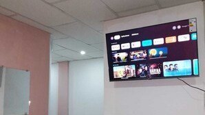 Ein Zimmer mit einem großen Flachbildfernseher an der Wand, der verschiedene Streaming-Dienste anzeigt.