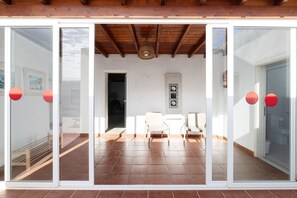 Un interior moderno con comedor, paredes blancas y suelo de baldosas.
