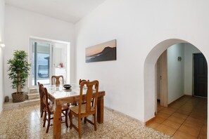 A dining area with a table and chairs, a potted plant, and a painting on the wall. - Vacation Home "Villa Sueños Zenoneisabel" with Sea View & 2 Private Terraces (Caleta del Sebo)