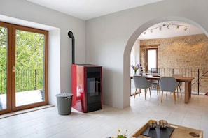 Een modern interieur met een open haard, een eetgedeelte en grote ramen.