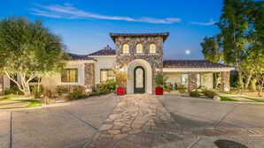 A modern house with a stone facade, a central arched entrance, and a well-maintained driveway. - Cinema+Golf S’m+P P’g +Volley+Basket+Pickle+G’room (Bermuda Dunes)