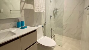 Ein modernes Badezimmer mit Toilette, Waschbecken und Dusche.
