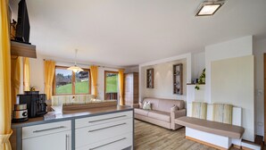 A modern kitchen with a built-in island, a sofa, and a bench.