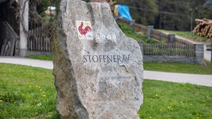 A stone monument with 'STOFFNERhof' and 'URLAUB. AM BAWERNHOF' inscribed on it.