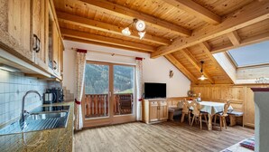 Een houten interieur met een keuken, een eethoek en een televisie.
