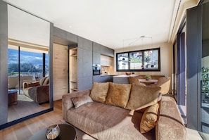 Un salon moderne avec un canapé, une table basse et une vue sur le paysage urbain.