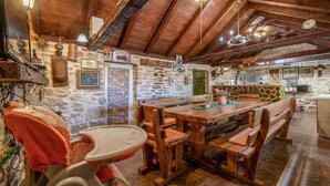 Un intérieur rustique avec des éléments en bois, un mur en pierre, des meubles en bois et un coin repas.
