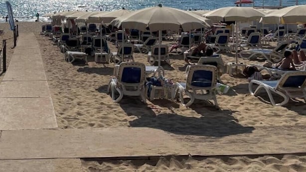 A beach with rows of sun loungers and umbrellas, a concrete walkway, and a clear view of the sea. - Holiday Home "Kastalia - La Relax" with Sea View, Shared Pool and Wi-Fi (Ragusa)