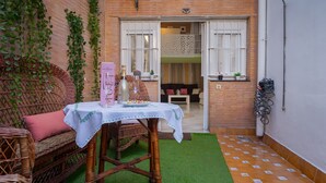 A wicker sofa with a table, a small indoor garden, and a view into the adjacent room. - Exclusive Duplex Penthouse with Private Terrace in the Heart of Seville (Sevilla)