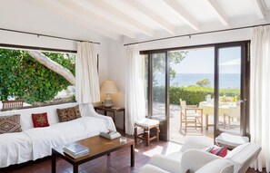 A room with a bed, a coffee table, and a view of the sea. - Holiday Home 'Casa Morant On The Promenade Mhm' with Sea View, Private Terrace and Wi-Fi (Cala Ratjada)