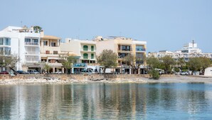 Un hôtel situé au bord de l’eau, avec plusieurs étages, des balcons et une vue dégagée sur le plan d’eau.