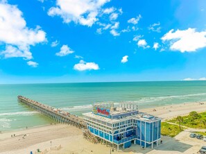 A pier extending into the ocean with a building at the end.