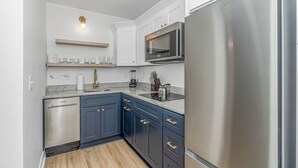 A modern kitchen with a stainless steel refrigerator, a microwave, and a dishwasher. - Myrtle Beach Haven . Walkable to Boardwalk, Beach & Dining. Pet Friendly! (Myrtle Beach)