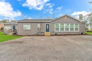 Ein zweistöckiges Haus mit Veranda, Garage und einem gepflegten Rasen.