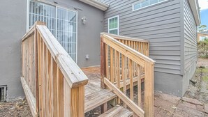 A house with a wooden deck and a gray exterior.