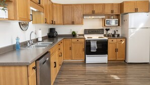 Una cocina moderna con armarios de madera, electrodomésticos de acero inoxidable y encimera de granito.