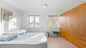 A bedroom with a bed, two windows, a wardrobe, and a painting on the wall. - Gorgeous home in søby ærø with WiFi (Søby Ærø)