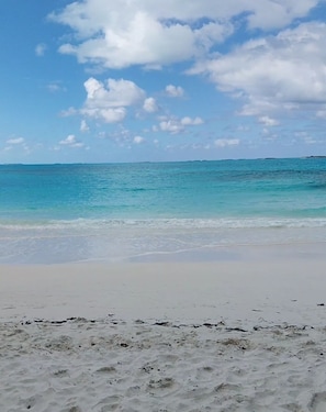 A beach with clear turquoise water and a sandy shore.