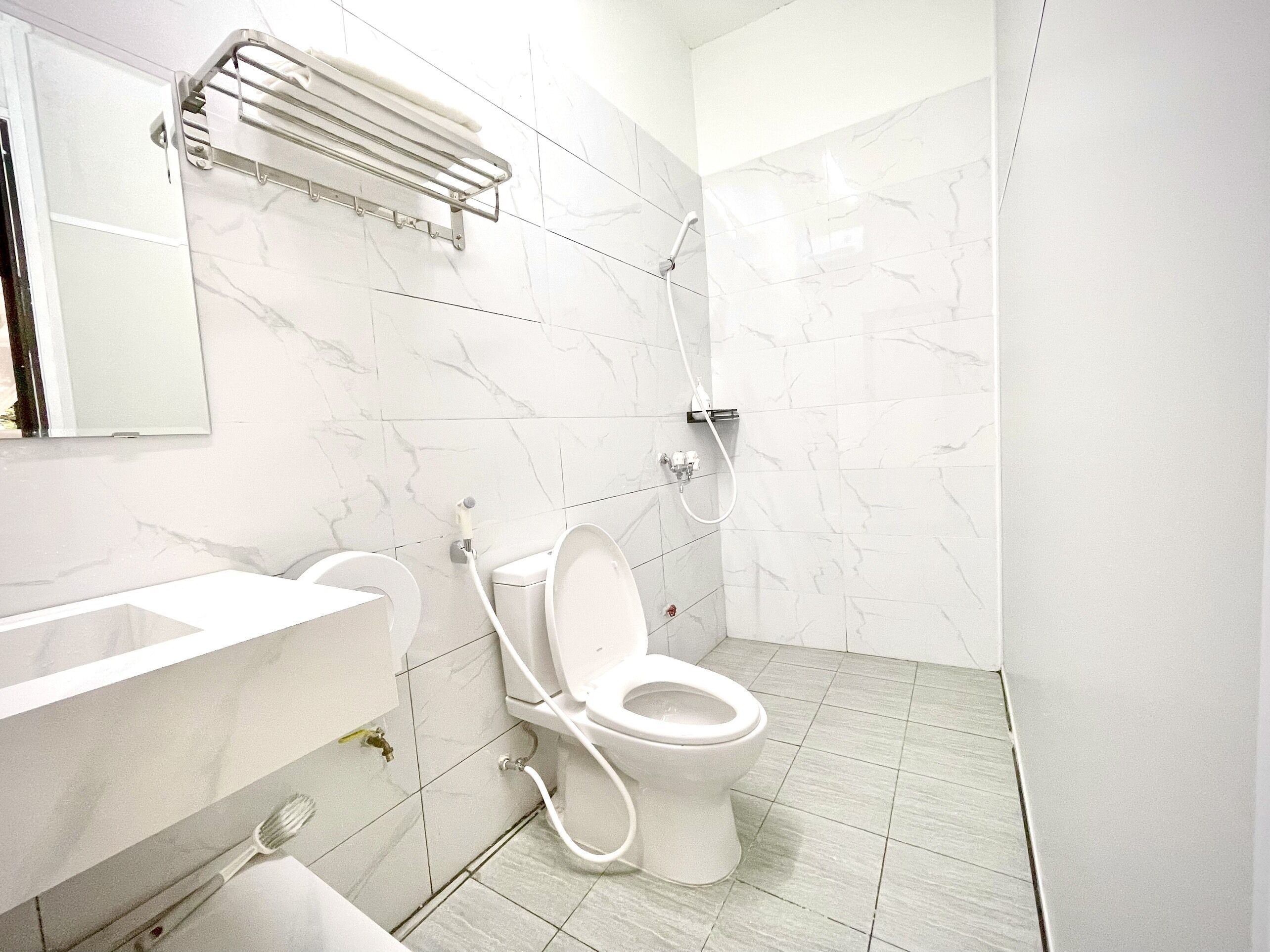 A modern bathroom with a toilet, sink, and shower.