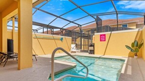 Una piscina interna con tetto in vetro, circondata da pareti gialle e pavimento piastrellato.