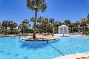 A clear blue pool with palm trees, lounge chairs, and a water fountain. - 2bd 2bth Beachside Oasis W/ Pool View  (Destin)