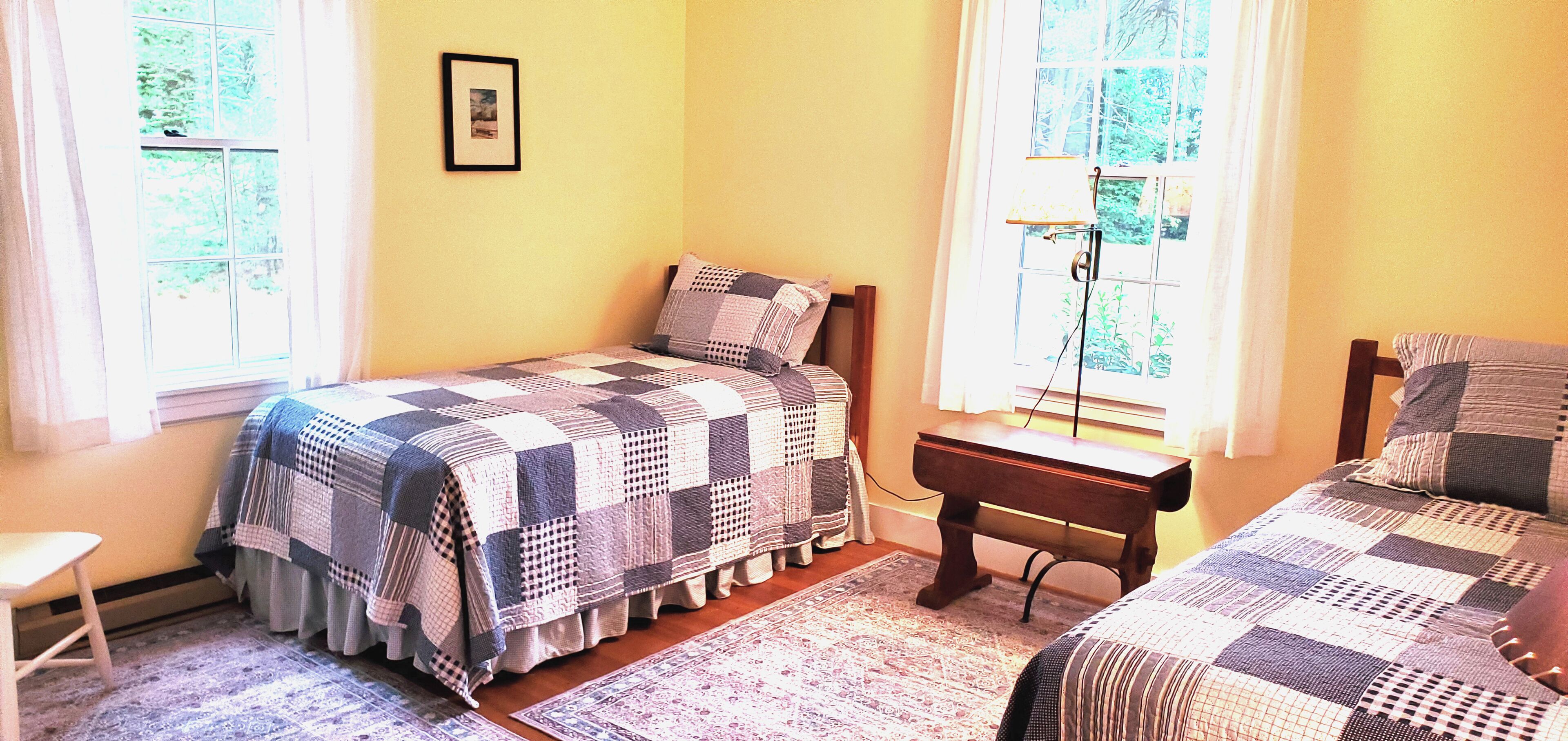 Une chambre avec deux lits, une petite table et une chaise.