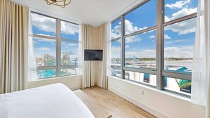 Ett hotellrum med stora fönster, en säng och en platt-TV.
