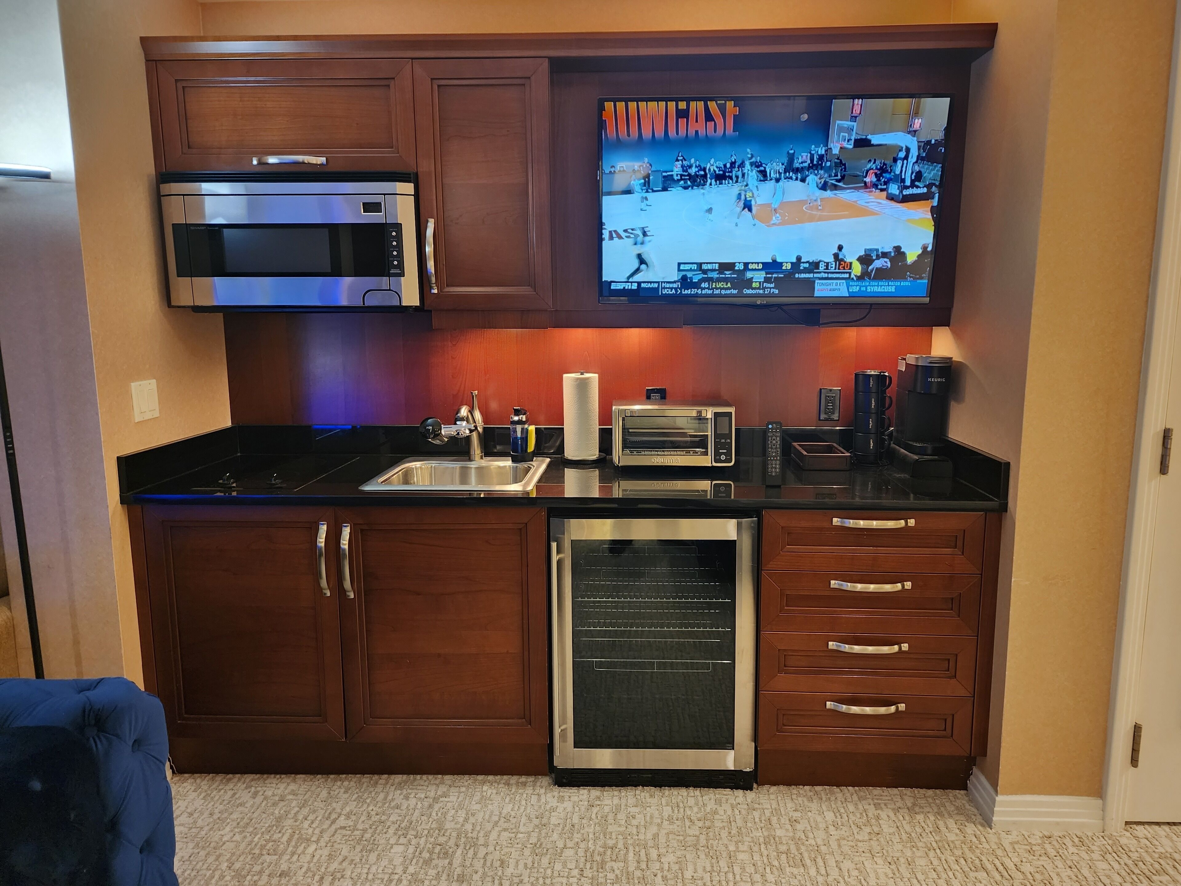 A compact kitchen with a built-in microwave, toaster, coffee maker, and dishwasher.