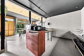 A modern kitchen with a wooden cabinet, a stove, and a dining area with a table and chairs.
