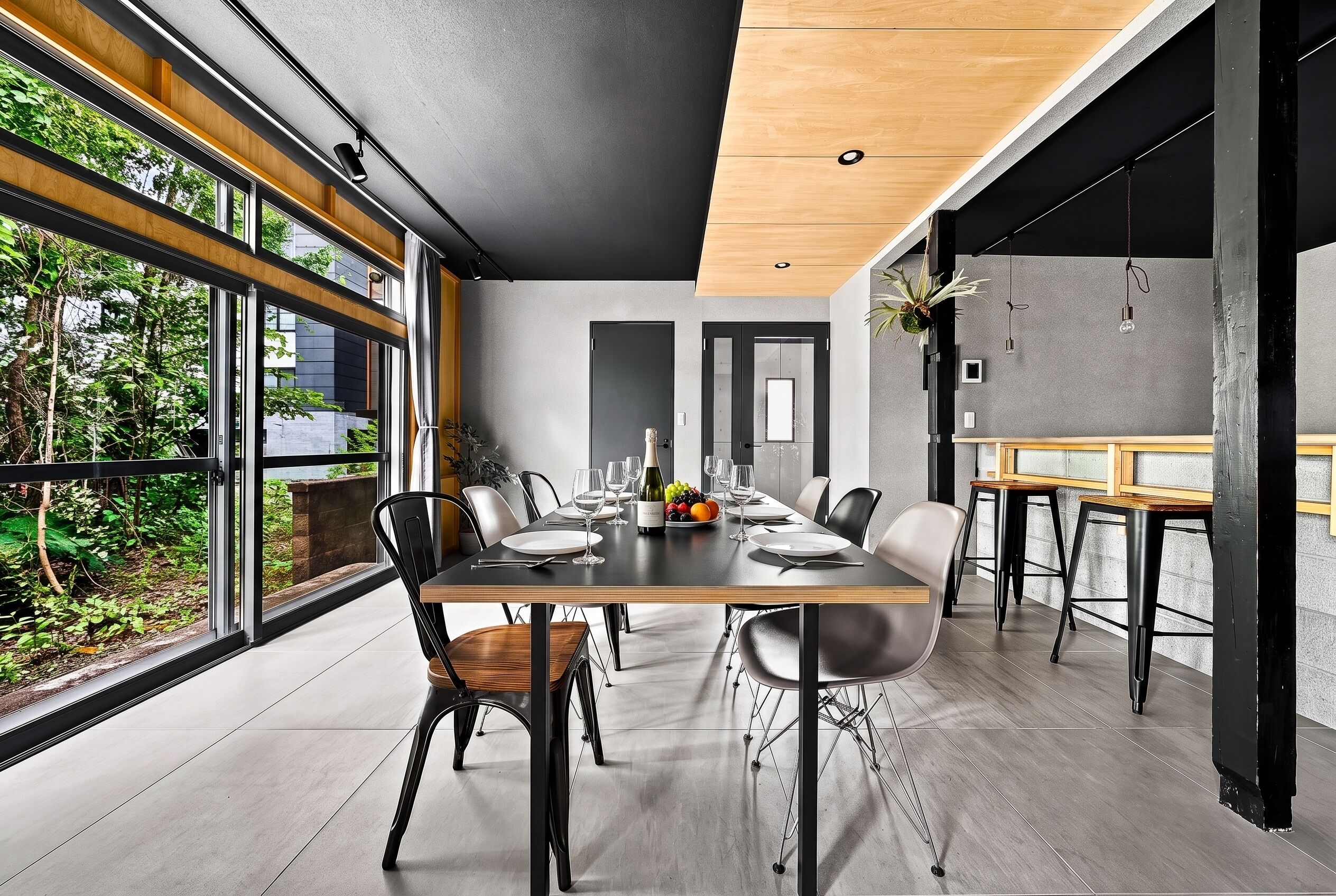 Un comedor moderno con una mesa larga, sillas y vistas al exterior.
