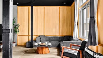 A modern living room with a sectional sofa, a coffee table, and a fireplace.