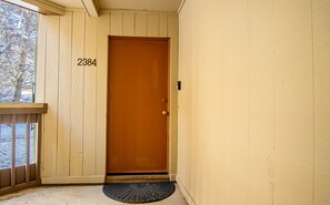 A wooden door with the number 2384, a doormat, and a window with a view of trees. - Indian Springs Oasis - Near Ski Slopes & Resort Amenities (Sun Valley)