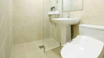 A modern bathroom with a shower, sink, and toilet.