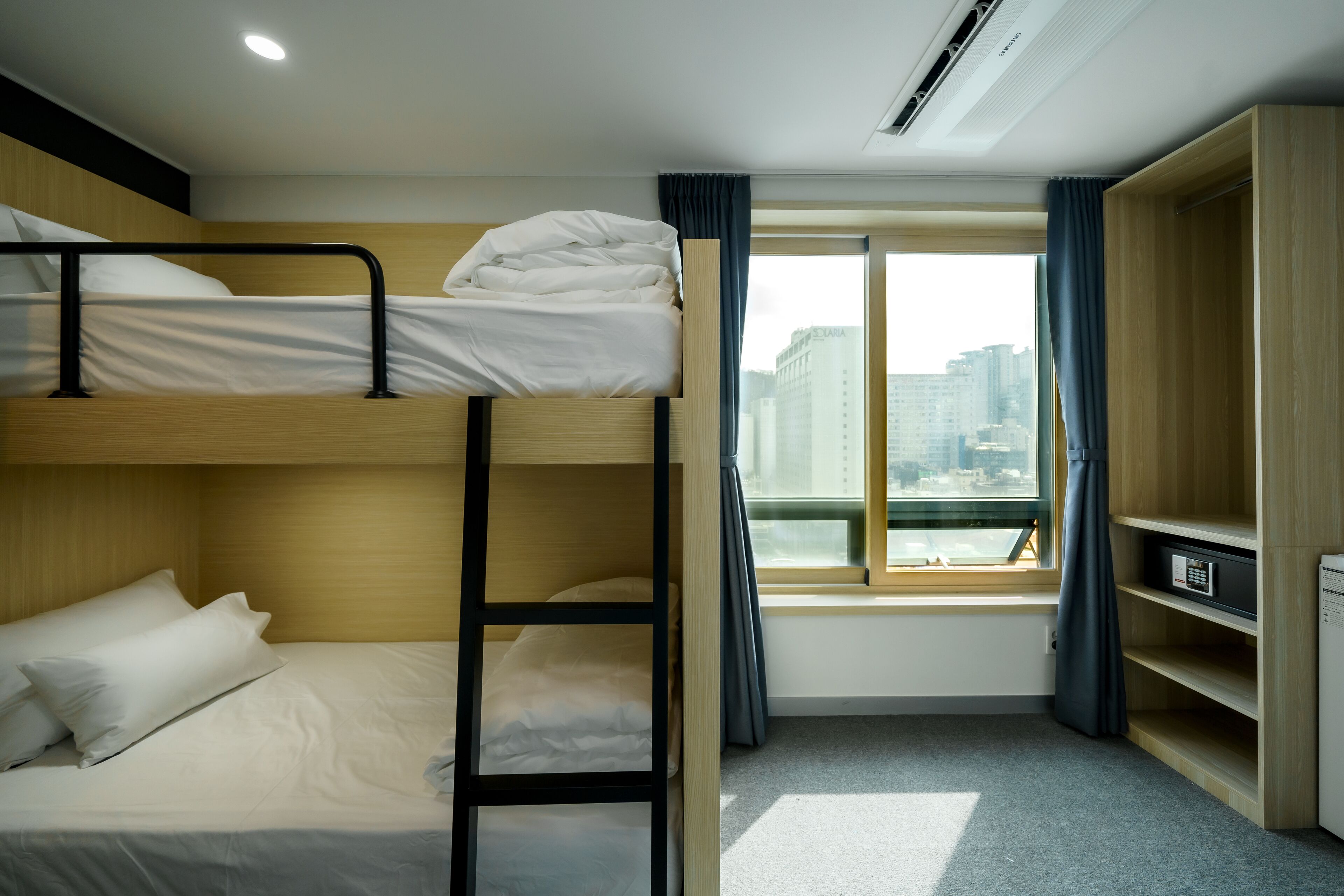 Habitación con literas, vista a la ciudad, un escritorio y un armario.