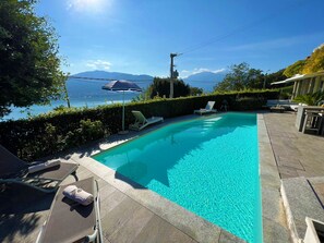 A swimming pool with a view of mountains and a clear sky.