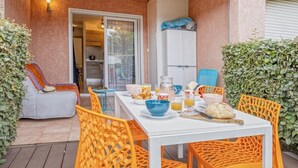 A breakfast setup with a table, chairs, and a kitchen in the background. - Casarella Massari (Oletta)