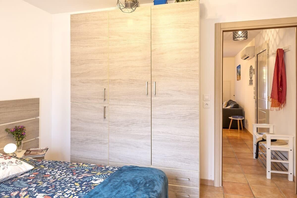 Una camera da letto con un letto, un armadio e un tavolino con una lampada.