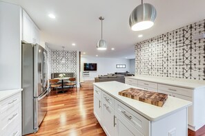 A modern kitchen with a central island, stainless steel appliances, and patterned backsplash. - EVANSTON whole building, 2 units combined sleeps 12, 5 bed 5 bath (Evanston)