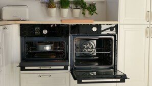 A kitchen with an oven, a microwave, and a small countertop.
