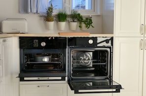 A kitchen with an oven, a microwave, and a small countertop.