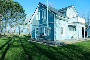 A large, two-story house with a blue exterior and a covered porch.
