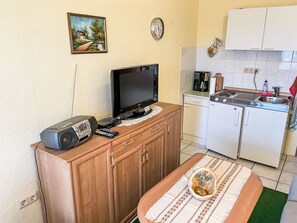 Kjøleskap, brødrister, høy barnestol og kjøkkenutstyr