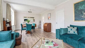 Un salon moderne comprenant un canapé, une table basse et un coin repas avec des chaises et une table.