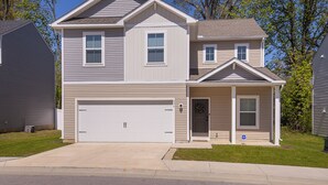 A two-story residential house with a garage, a front porch, and a small attached garage.