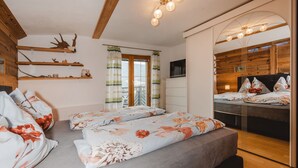 Ein Schlafzimmer mit einem Bett, einem Fernseher und einer Holzbalkendecke.